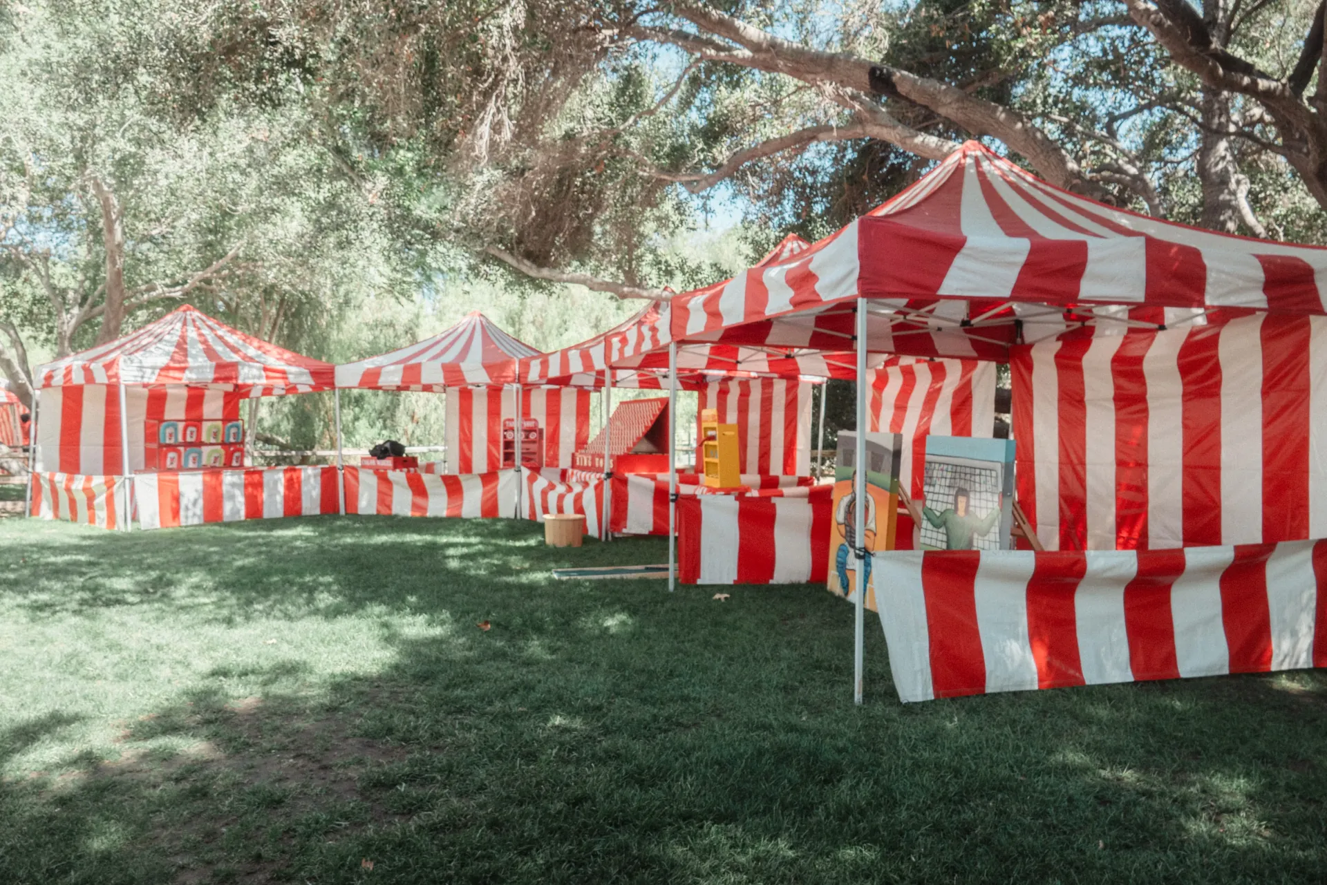 A high-capacity concession hub at a municipal event with multiple popcorn and cotton candy machines being operated by staff
