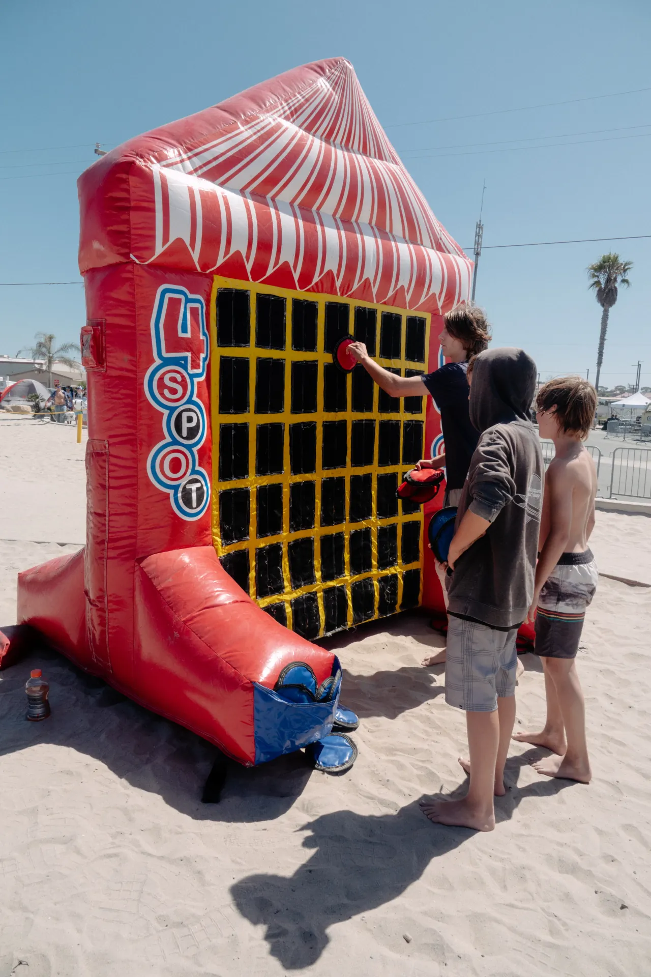 A row of professionally striped carnival games set up on a park field, showing the scale and organization of a municipal event